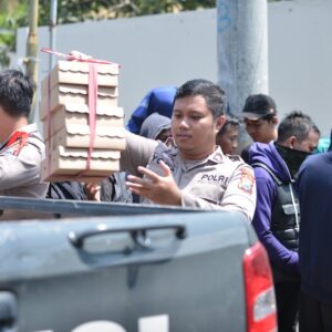 *Humanis, Polisi Berbagi Nasi Kotak untuk Peserta Unras Sarbumusi Situbondo*