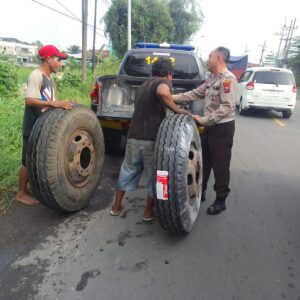 *Salut, Pak Polisi ini Bantu Sopir Truk Ganti Ban di Tengah Padatnya Lalin Gresik*